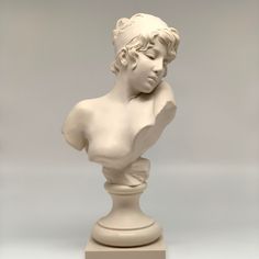 a white sculpture of a woman's head on a pedestal