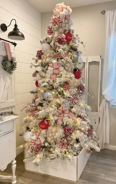 a white christmas tree with red and silver ornaments