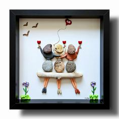 a shadow box frame with rocks and wine glasses on it, as if they were floating in the air