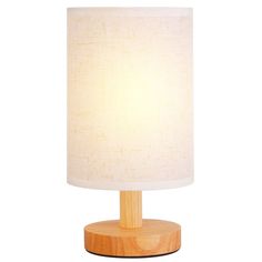 a wooden table lamp with a white shade