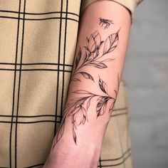 a woman's arm with a flower tattoo on the left side of her arm