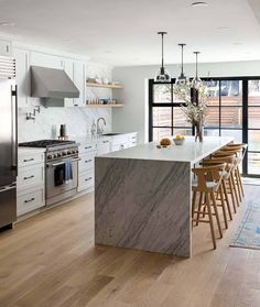 a kitchen with marble counter tops and an island in front of a stove top oven