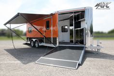 an orange and silver trailer parked on top of a dirt field