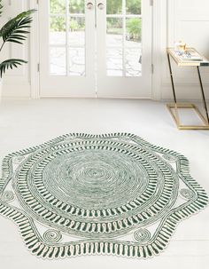 a green and white area rug with an intricate design on the floor in front of a door