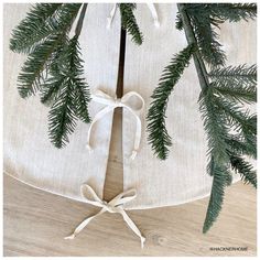 the table is decorated with pine branches and white linens, tied in twine