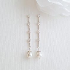 Delicate and dainty, the Ginger earrings are long created in a simple style with tiny 4mm cubic zirconia round crystals interspersed with shiny etched metal. I have added a Swarovski round pearl drop to them. They are lightweight drop earrings and comfortable for long wear. They will swing and dance when worn, the little crystals catch the light for the sparkle and yet are understated and great for some one looking for minimalist earrings. Earrings are made with cubic zirconia and all material u White Dainty Cubic Zirconia Bridal Earrings, Dainty White Cubic Zirconia Bridal Earrings, Classic Diamond White Linear Earrings For Wedding, Wedding Sterling Silver Linear Earrings With Diamond Accents, Silver Linear Earrings With Pearl Drop For Anniversary, White Cubic Zirconia Dangle Earrings, Minimalist Cubic Zirconia Wedding Earrings, Minimalist Round Linear Earrings For Wedding, Delicate Dangle Cubic Zirconia Pearl Earrings