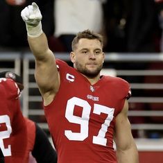 a football player holding his arm up in the air with one hand and two other hands raised