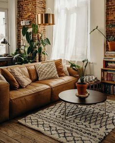 a living room filled with furniture and a large window next to a bookshelf