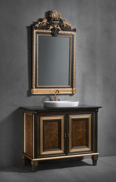 a bathroom vanity with an ornate mirror above it