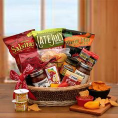 a basket filled with snacks and condiments sitting on top of a wooden table