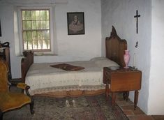 a bedroom with a bed, dresser and chair in it