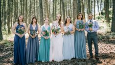 a group of people standing next to each other in the woods