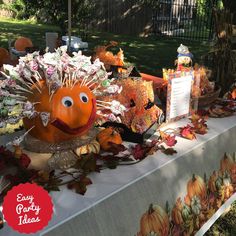 a table topped with lots of fake pumpkins and other items on top of it