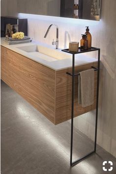 a bathroom with a sink, mirror and soap dispenser