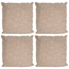 four beige pillows with white crosses on them