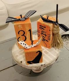 three wooden blocks with black and white numbers on them are sitting on a plate that has a tassel tied to it