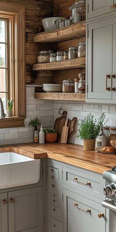 a kitchen filled with lots of wooden counter tops and white cupboards next to a window