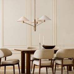 a dining room table with four chairs and a chandelier hanging from the ceiling