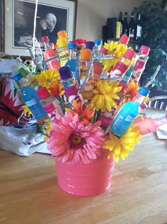 a pink vase filled with lots of colorful flowers