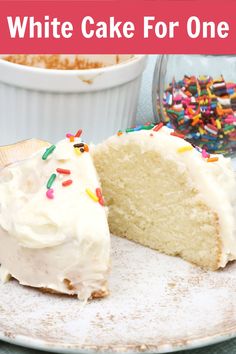 a piece of cake with white frosting and sprinkles on it is sitting on a plate