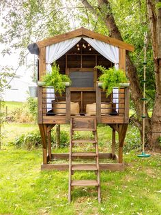 a wooden structure with plants on it in the grass