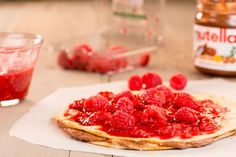 raspberry spread on top of an uncooked flatbread with yogurt in the background