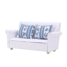 a white couch with blue and white pillows on it's armrests, against a white background