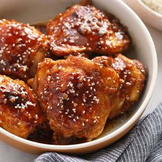 a bowl filled with chicken wings covered in sesame seeds