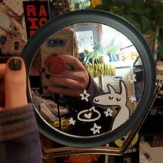 a person taking a selfie in the mirror with their cell phone and dog sticker on it