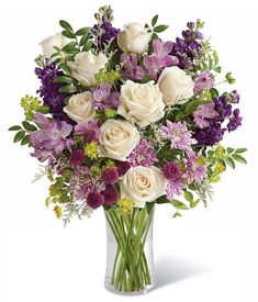 a vase filled with lots of purple and white flowers