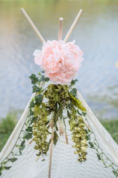 a teepee with pink flowers and greenery on it