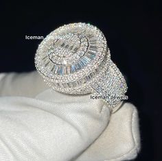 a diamond ring sitting on top of a white cloth covered napkin with the words iceman written below it