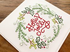 an embroidered christmas wreath on a white card