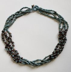 Handmade necklace of four strands of Turquoise-colored Seed Bead with Wood Bead accents. Turquoise Wooden Beads For Jewelry Making, Turquoise Multi-strand Beaded Necklaces With Tiny Beads, Turquoise Multi-strand Tiny Beads Necklace, Turquoise Multi-strand Beaded Necklaces, Double Strand Turquoise Beaded Necklace For Beach, Turquoise Double Strand Beaded Necklace For Beach, Turquoise Multi-strand Tiny Beads, Turquoise Necklace With Wooden Round Beads, Turquoise Necklace With Wooden Beads