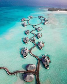 an aerial view of the ocean with several boats in it and some sand around them