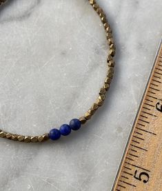 Lapis Lazuli and Faceted Brass Beaded Bracelet. Three 4 mm round lapis lazuli beads with 2-2.5 mm diamond cut faceted brass beads make up this bracelet, which closes with a lobster claw clasp. Also available in silver.I welcome custom orders! I can make this bracelet with other semi precious stones and silver or brass beads. The third photo shows other bracket options that are currently available.Arrives in a gift box. Brass Beaded Bracelets With Round Beads, Brass Bracelets With Round Beads As Gift, Brass Bracelets With Round Beads For Gifts, Adjustable Lapis Lazuli Beaded Bracelets For Everyday, Adjustable Lapis Lazuli Beaded Bracelet With Faceted Beads, Adjustable Lapis Lazuli Stretch Bracelet With Round Beads, Hand-strung Brass Bracelets With Round Beads, Adjustable Lapis Lazuli Jewelry With Faceted Beads, Brass Spacer Beads Jewelry