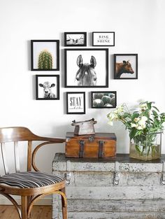 an old trunk is sitting in front of a wall with pictures and flowers on it