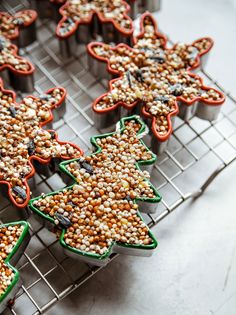 christmas tree shaped cupcakes with sprinkles on them sitting on a cooling rack