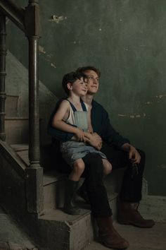 a man and boy sitting on some stairs