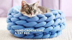 a cat is laying on top of a bed made out of blue yarn and has the caption hand - crocheting a cat bed