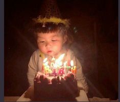 a little boy that is sitting in front of a birthday cake with candles on it