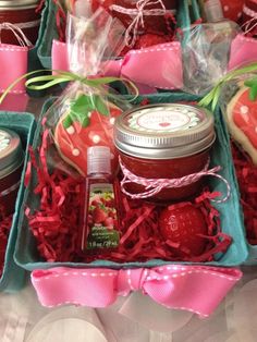 strawberry shortcakes, jam and cookies are arranged in baskets on a table with pink bows