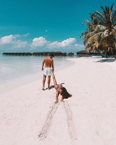 two people on the beach playing in the sand