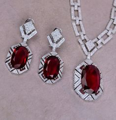 Check out this stunning Unique Oval Cut Ruby Sapphire Pendant Necklace Set. The long pendant necklace features beautiful micro cubic zirconia detailing throughout the chain, making it perfect for any occasion. The pictures don't do justice to this lovely set. Pendant Length: 1.6" Neckline Length: 13.75" can be adjusted with chain. Earring Lenght: 2.5". comes with omega clip for extra support Push-Back closure. Silver Polish on high-quality brass as a base metal. Availability: In-Stock. *Color may vary slightly due to light condition & photography. Jewelry Care: Keep away from moisture. Allow perfumes and lotion to dry before wearing. Store in jewelry pouch. Clean only with soft lint free cloth. American Diamond Ring, Contemporary Bracelets, Sapphire Necklace Pendants, American Diamond Necklaces, Contemporary Necklace, Bangle Ring, Contemporary Earrings, Traditional Earrings, Studded Necklace