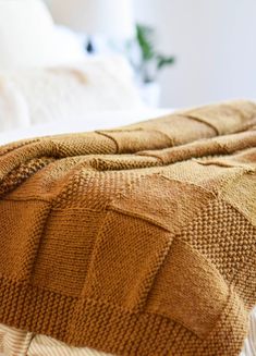 a bed with a brown blanket on top of it