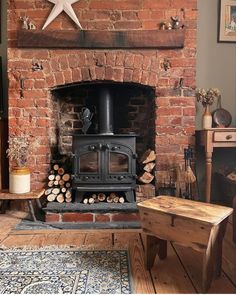 an old brick fireplace with logs stacked on the floor and a star above it, in a living room