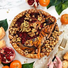 a pie decorated with oranges, cranberries and nuts on a white table