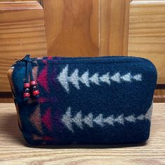 This cute cosmetic bag is handcrafted from quality Pendleton® blanket weight napped (fuzzy) wool.  It is just the right size for a cosmetics, travel size hygiene products, medications, gadget / device  cords, jewelry, or whatever!   Dimensions (inches): Width:  8 Height:  5 3/4 Gusset:  2 This pouch stands by itself.  The front and back are the same. This bag is unlined because the inside is pretty too, and all seams are finished. It has a heavy duty purse zipper and coordinating Leather zipper pull with glass crow beads for extra detail.  More Night Owl Market Cosmetic Bags:  https://www.etsy.com/shop/NightOwlMarket?section_id=6814373 Home Page:  http://www.etsy.com/shop/NightOwlMarket Pendleton Cosmetics Bag, Pendleton Blanket, Pendleton Woolen Mills, Bag Makeup, Zippered Pouch, Night Owl, Toiletry Storage, Leather Zipper, Cosmetic Bags