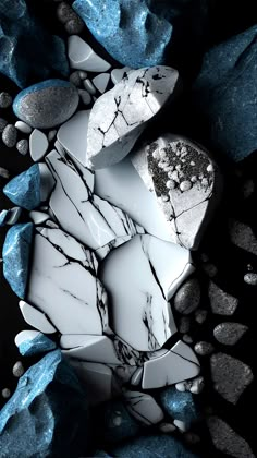 some rocks are laying on the ground with blue and white stones around them in black and white