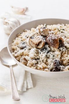 a bowl filled with rice and mushrooms covered in parmesan cheese